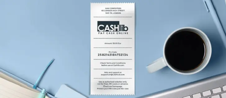 Bon prépayé Cashlib de 50 euros posé sur un bureau avec un café et un ordinateur portable