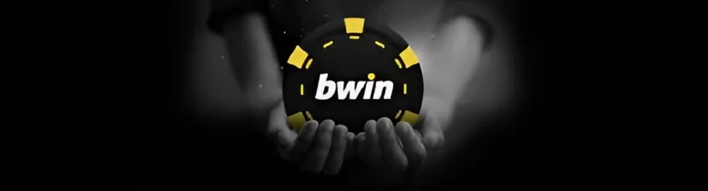  Jeton noir et jaune avec le logo Bwin Poker tenu entre deux mains, sur fond sombre, image promotionnelle de la marque
