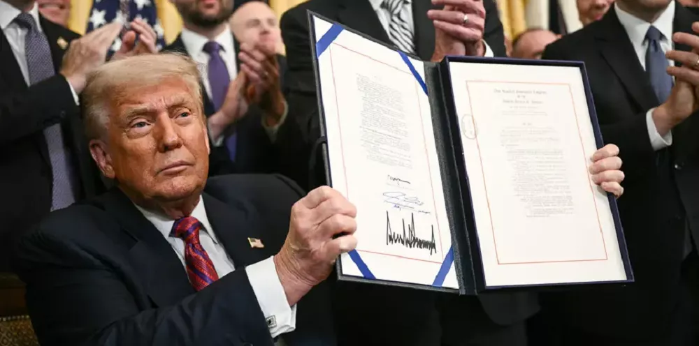 Donald Trump présente le Genius Act USA signé, entouré de collaborateurs applaudissant la nouvelle loi sur les stablecoins