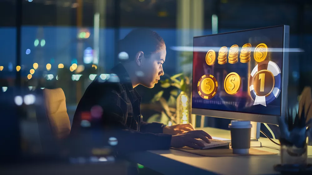 Femme concentrée sur un jeu en ligne pour gagner de l'argent, écran affichant des gains, ambiance nocturne moderne.