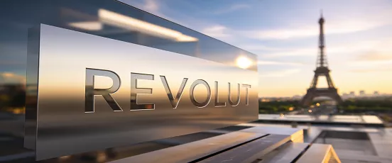 Panneau Revolut en métal avec vue sur la Tour Eiffel au coucher du soleil, illustrant l’installation du siège à Paris