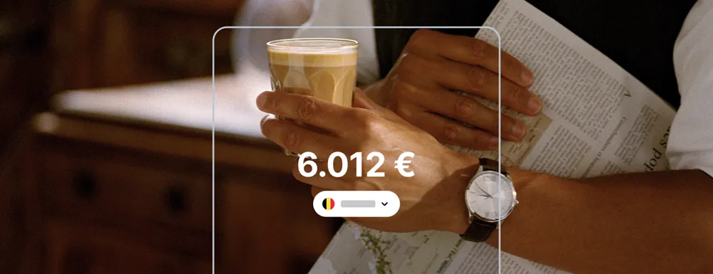 Main tenant un café et un journal avec un solde Revolut affiché à 6.012 €, illustrant un compte Revolut belge actif